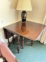 Table with one leaf dropped, lamp on top