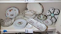 Shelf with assorted porcelain plates, platters, cut glass bowls and pressed glass dish