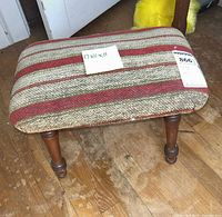 Top view of footstool showing striped upholstery and note with dimensions