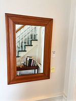 Front view of rectangular wood-framed mirror on wall