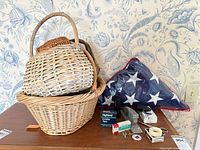 Grouped view of three wicker baskets, folded flag, office supply boxes, flashlight, scissors, tape and accessories