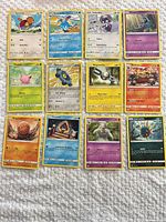 Overview of all 12 Pokémon cards laid out on white surface
