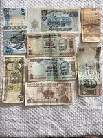 All eight banknotes laid out on cloth for overview