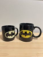 Both mugs side by side showing size difference and logos