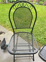 Full view of black metal patio chair on patio
