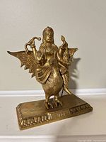 Front view of brass Shani Dev statue on base