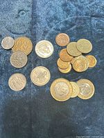 All coins laid out on blue cloth showing variety and quantity