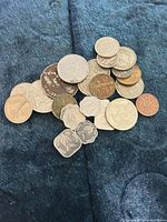 Pile of assorted world coins on blue fabric
