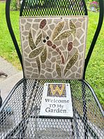 Both plaques on metal chair showing size relationship