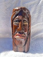 Front view of carved cedar warrior head showing overall form and facial details