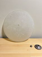 front view of round frosted marbled glass shade with mounting hole, cap and nut shown