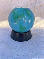 Front view of globe on base showing continents and ocean color