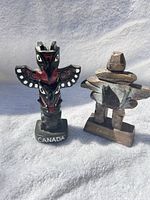 Totem pole and inukshuk figurines side by side