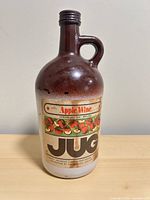 Front view of brown gradient glass jug with Apple Wine label
