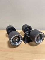Two skateboard trucks with wheels angled front view