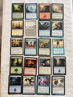 Full layout of 20 Magic: The Gathering cards on cloth surface