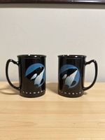 two identical black SeaWorld killer whale mugs front view