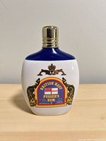 Front view of porcelain Pusser's Rum decanter showing label and cap