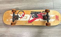 Top view of entire skateboard showing deck graphic, trucks, wheels