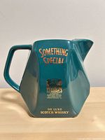Left side view of teal ceramic whisky advertising pitcher