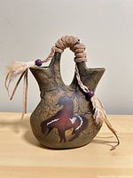 Front view of double-spout ceramic vase showing horse motif and crackle glaze