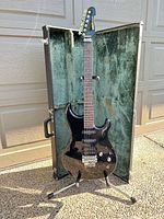 Front view of Yamaha SE550 guitar inside open green-lined hard case