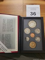 Open presentation case showing all eight proof coins and certificate