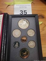 Obverse view of seven encapsulated coins in case