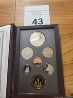 Open case showing seven uncirculated coins and certificate