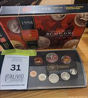 Display case with eight proof coins and outer 1998 RCMP anniversary sleeve