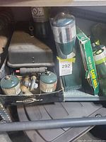 Multiple propane cylinders, regulator, Coleman stove and boxed grill in storage compartment