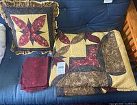 quilt, decorative pillow and pillowcases arranged on couch