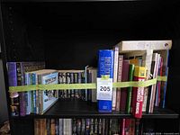 Overall view of shelf showing mixed books strapped for stability