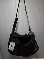Full view of black Nike duffel bag hanging, showing overall design and strap