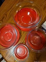 Stacked clear glass bowls with red lids