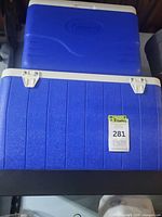 Top view of stacked blue Coleman coolers showing lids