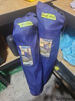 Two blue carry bags with River Trail labels standing upright on shelf