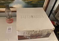 Boxed Fifth Avenue Crystal punch bowl set beside glass oil lamp