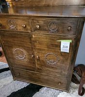 Front view of cabinet showing drawers, doors, hardware, carved details