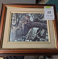 Front view of framed leopard print showing wood, gold trim, linen mat