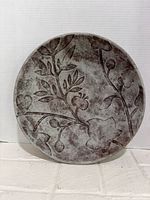 Top view of concrete bowl displaying full floral relief design and overall condition