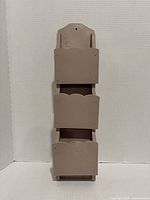 Full front view of beige wood wall organizer showing three compartments and mounting hole