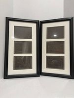 Both black triple-opening picture frames standing side by side