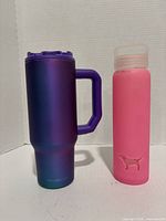FrostBuddy travel mug and pink water bottle side by side