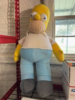 Full front view of Homer Simpson plush standing on shelf