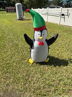 Front view of inflatable penguin showing bow tie, facial details, hat, and feet