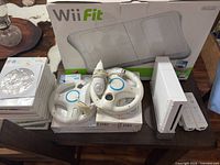 Overall view of Wii console, balance board box, wheels, game stack