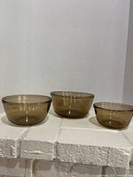 Three amber Pyrex/Corning mixing bowls in nested arrangement