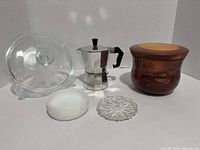 Group shot of all five items: moka pot, wood canister, clear glass lidded dish, milk glass bowl, pressed-glass dish