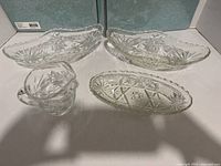 Four pressed glass pieces: two large oval bowls, small oval dish, creamer